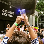 空のカップを頭上に掲げる男性